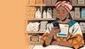 Nigerian shop owner smiling at her phone behind her provision-store counter, sharing an invoice